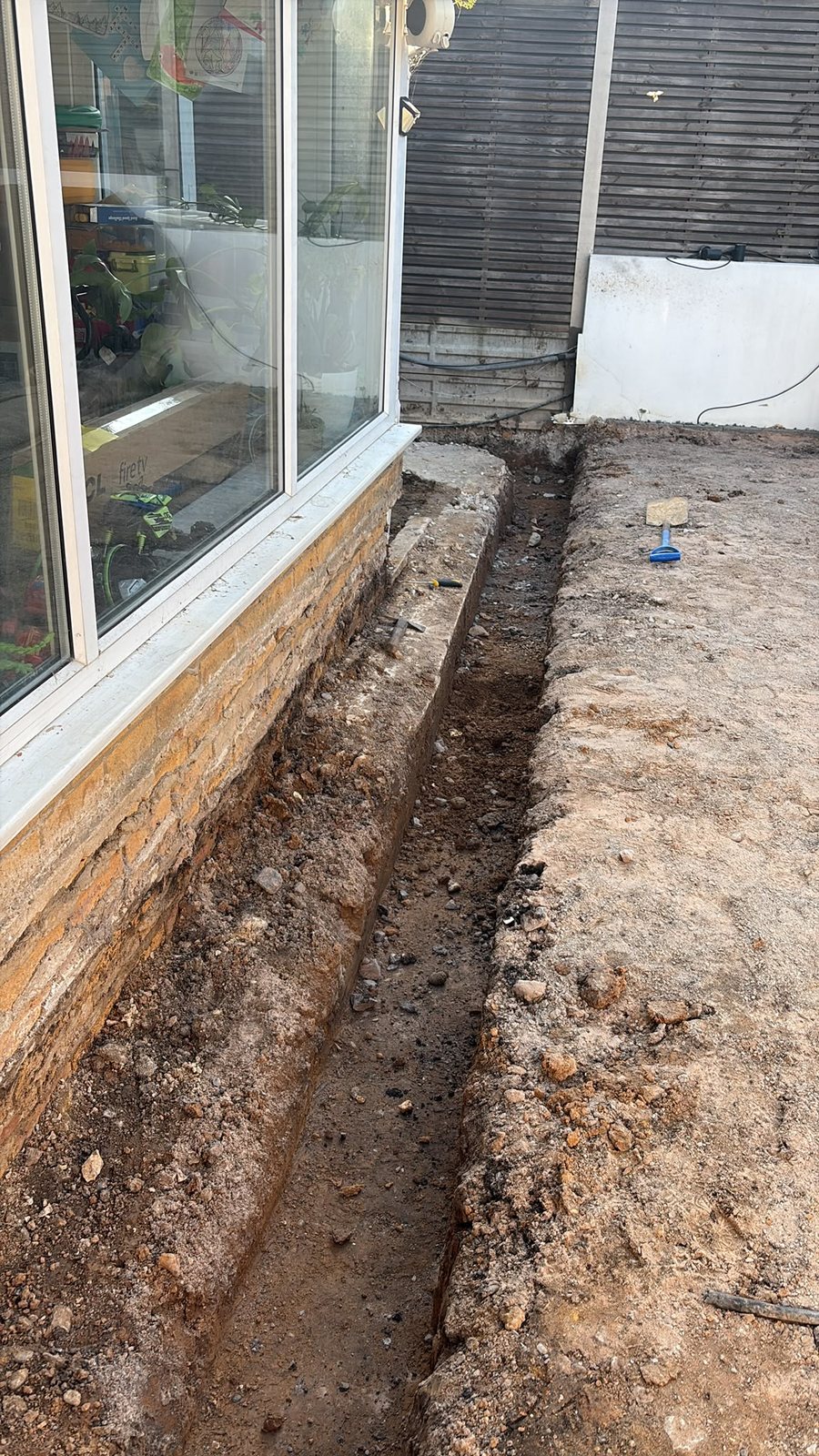 Trench dug alongside a building for new services